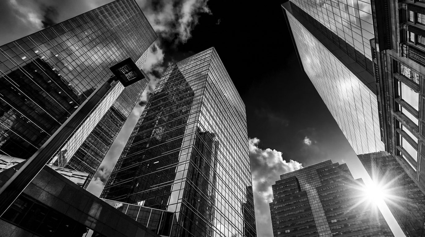 Glass towers viewed from below against a dark sky